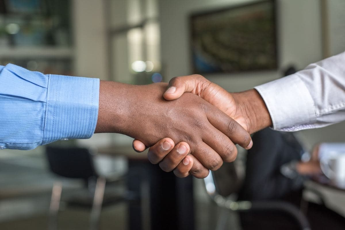 Two people shaking hands over a completed agreement