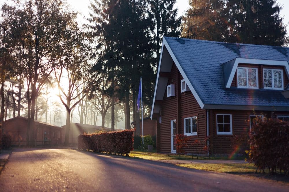 An older detached home on a quiet residential street at dusk