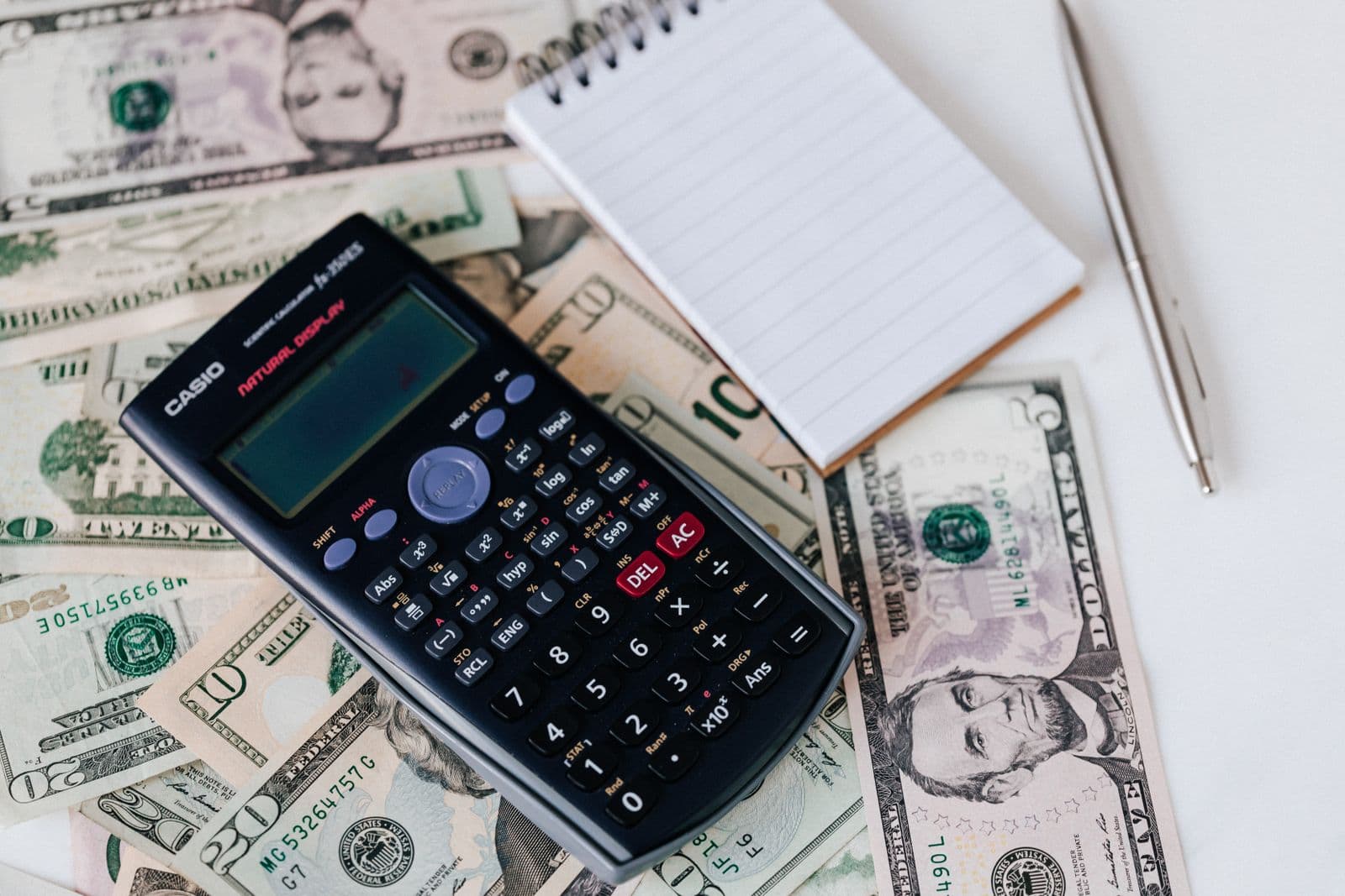 A calculator and notepad on a desk while budgeting a campaign