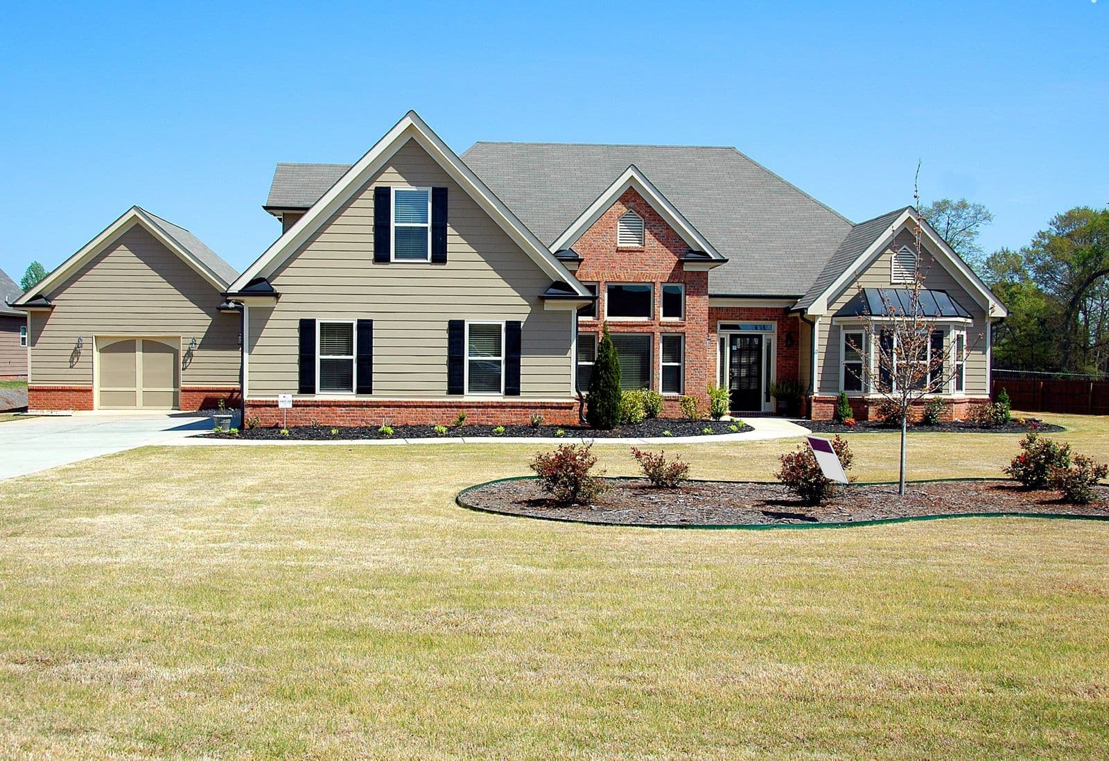 A suburban family home with a patchy, dried out front lawn
